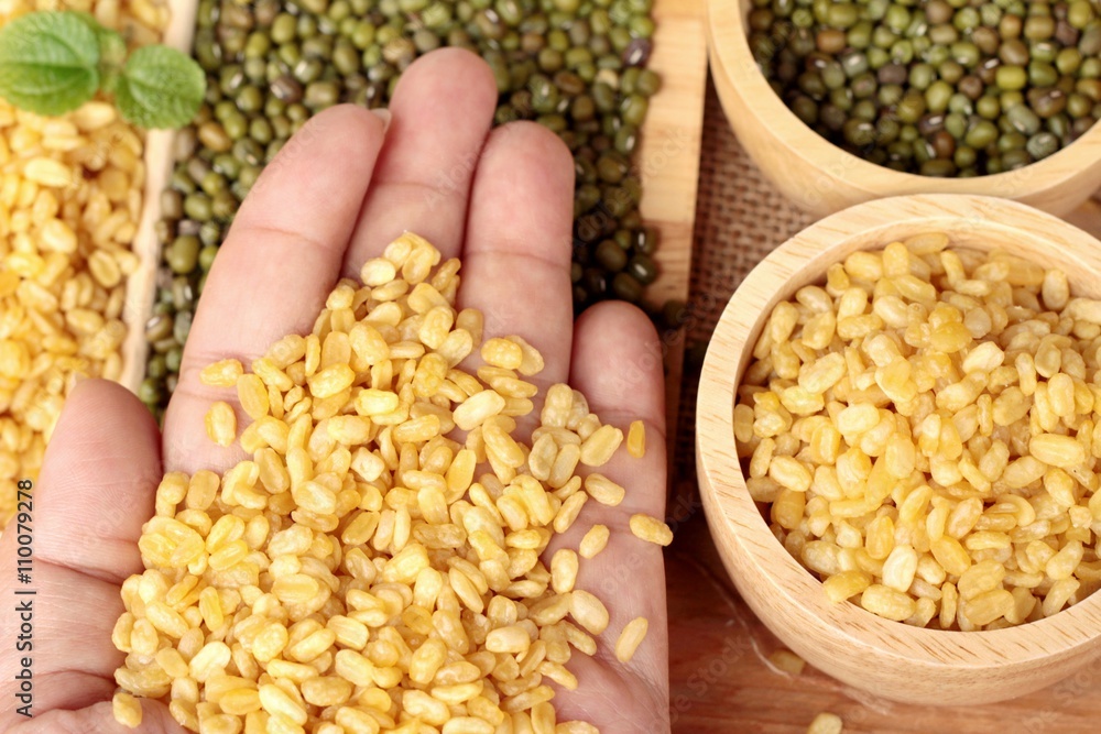 Soy beans and dry beans on wood background.