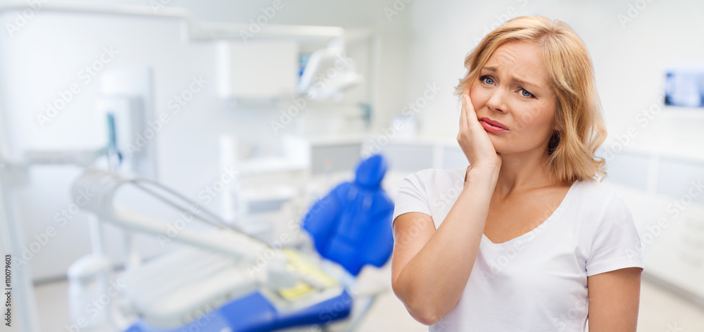 unhappy woman suffering toothache at dental office unhappy woman suffering toothache at dental office