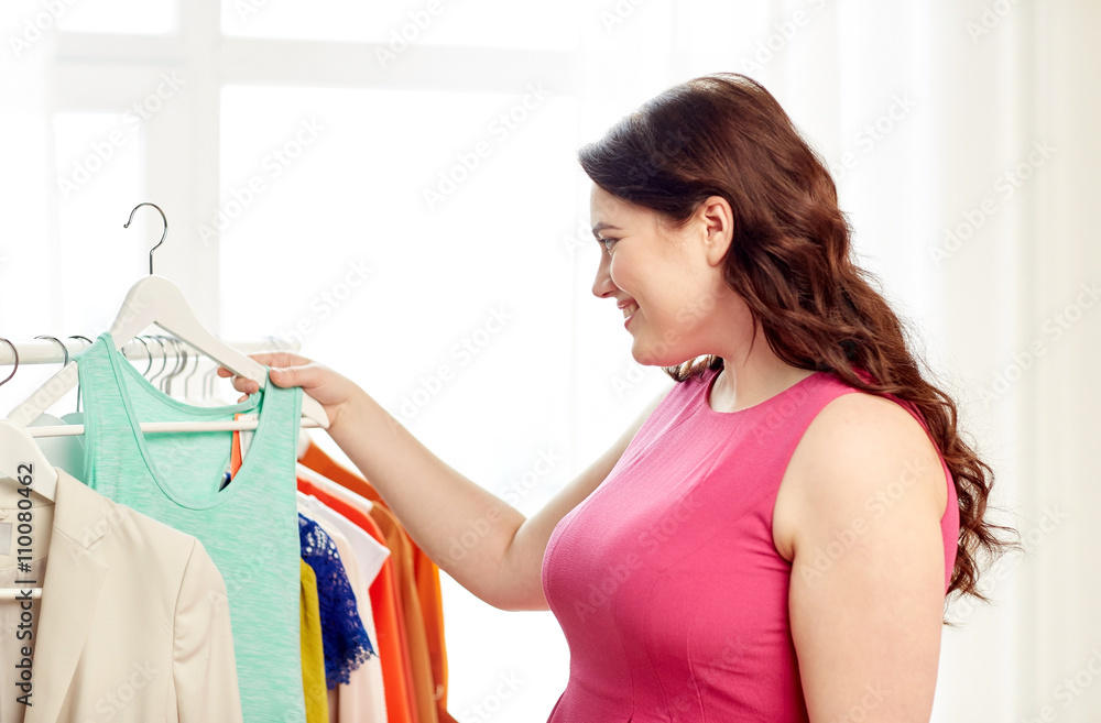 happy plus size woman choosing clothes at wardrobe happy plus size woman choosing clothes at wardrobe