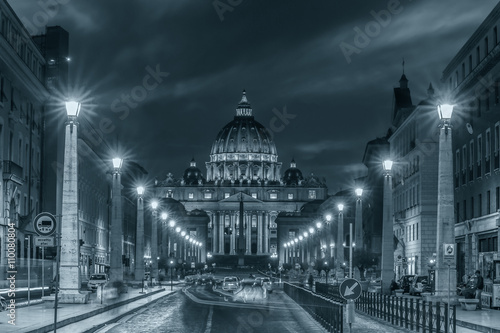 City view with car lights and Basilica of Saint Peter in Vatican at night. Rome, Italy. /White balance changed/