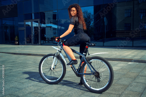 serious brunette sports woman with bicycle
