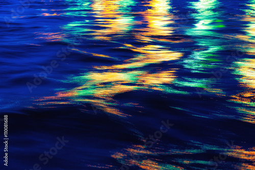 City lights reflection. Colorful glare on the water