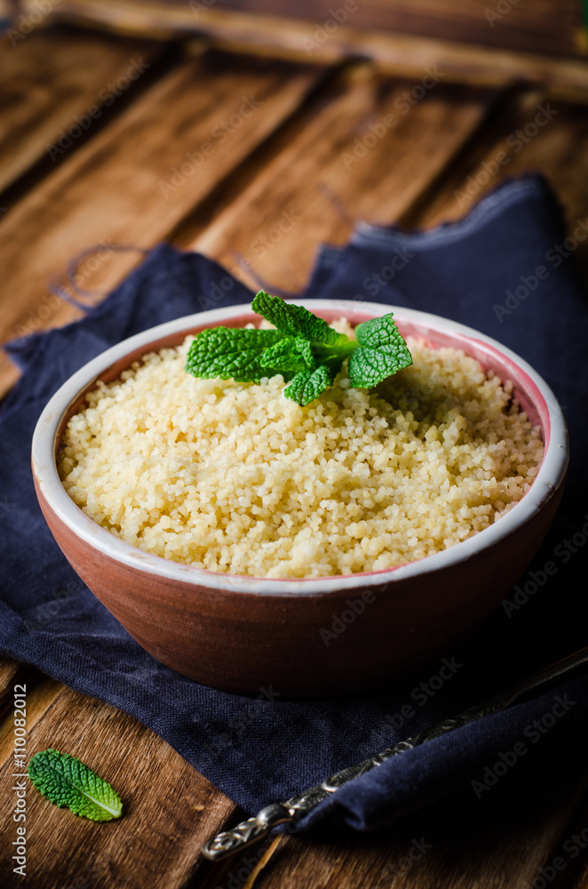 Boiled couscous in clay bowl on wooden background. Selective focus Boiled couscous in clay bowl on wooden background. Selective focus