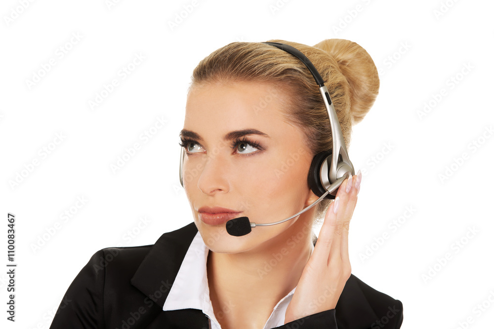 Young woman helpline operator is trying to hear something headphones Young woman helpline operator is trying to hear something headphones