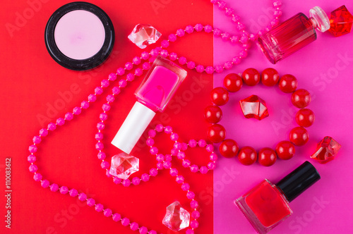 Summer Accessories and Cosmetics for relaxing on fuchsia background - sunglasses, lipstick, powder, colored beads, nail polish. View from above. Flat lay.