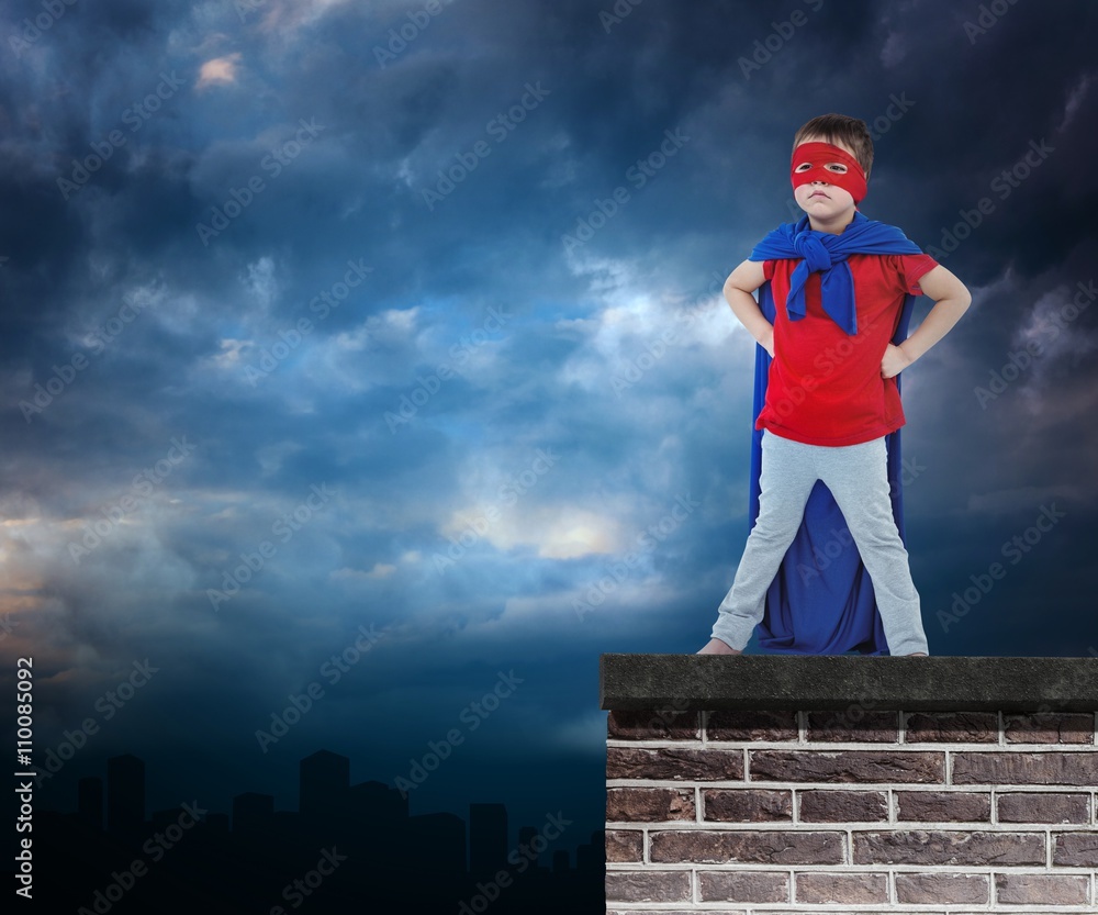 Composite image of masked boy pretending to be superhero Composite image of masked boy pretending to be superhero