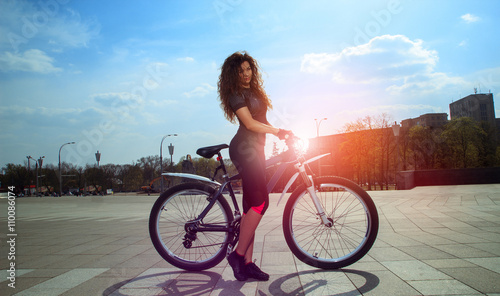 charming curly girl on a bicycle