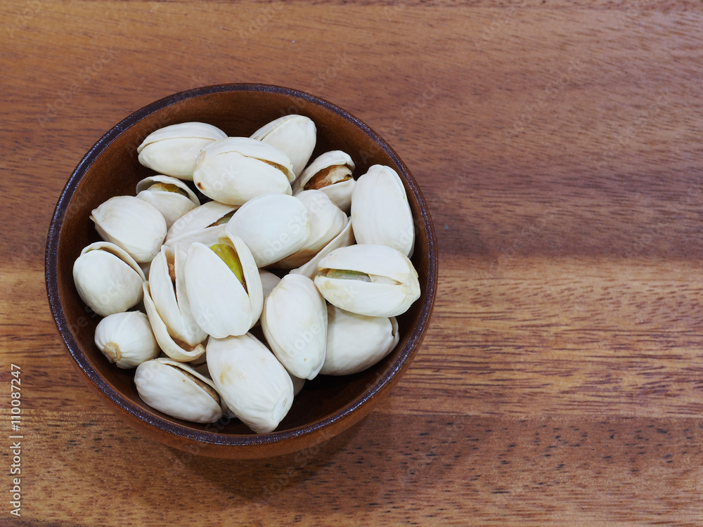 roasted and salted pistachios on wooden background roasted and salted pistachios on wooden background