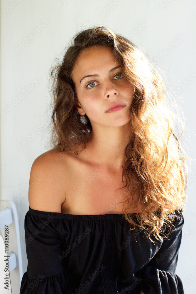 Fototapeta premium Beautiful young woman with curly hair staring