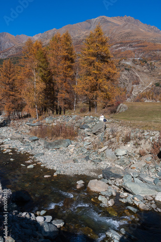 Nun reading by river in Cogne Gran Paradiso Park Valle d'Aosta Italy