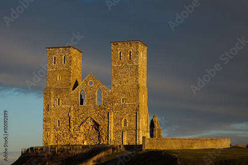 Remains of Reculver church towers bathed in late afternoon sun in winter photo