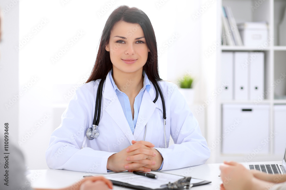 Brunette female doctor talking to patient in the hospital Brunette female doctor talking to patient in the hospital