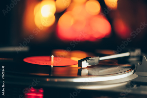 turntable with LP vinyl record against burning fire background