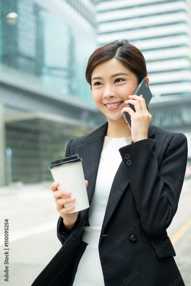 Young Businesswoman talk to phone and hold with coffee cup Young Businesswoman talk to phone and hold with coffee cup
