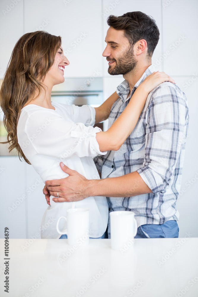Fototapeta premium Couple embracing by table at home