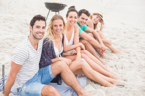 Group of friends sitting side by side on the beach © WavebreakmediaMicro