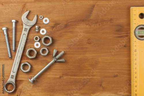 Bolt and nut on a wooden background. Mounting spanner. Background with working tools. Workshop equipment. Buyers repairman. 