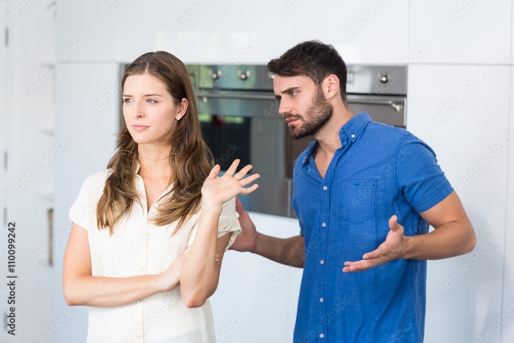Obraz premium Man explaining to upset wife in kitchen 