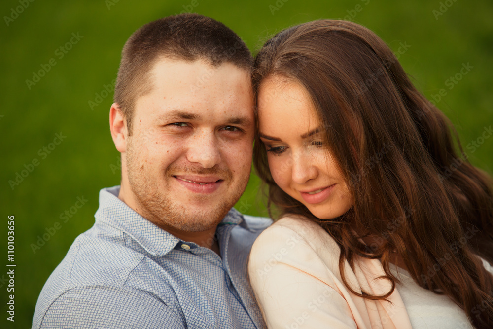 Happy Smiling Couple Relaxing on Green Grass.Park Happy Smiling Couple Relaxing on Green Grass.Park