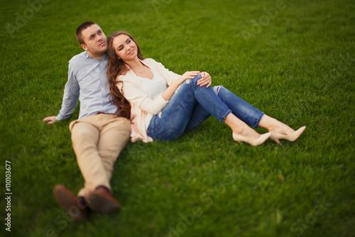 Happy Smiling Couple Relaxing on Green Grass.Park