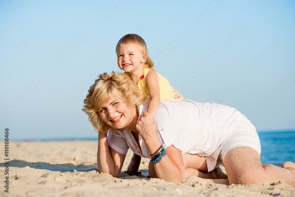 Mama with a daughter playing on the beach Mama with a daughter playing on the beach