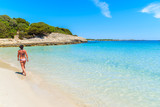 Unidentified attractive young woman in swimsuit walking along beautiful Petit Sperone beach on Corsica island, France