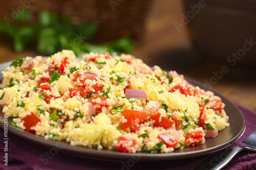 Taboule, ein arabischer vegetarischer Salat aus Couscous, Tomate, Gurke, Zwiebel, Knoblauch, Petersilie, Zitronensaft (Selektiver Fokus, Fokus ein Drittel in das Gericht)