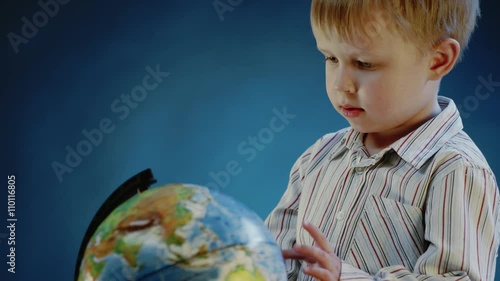 little boy rotates the globe