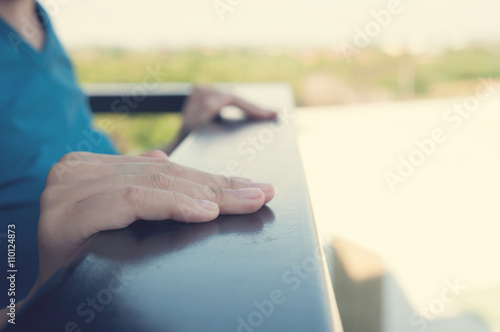 Hands of woman on handrail.