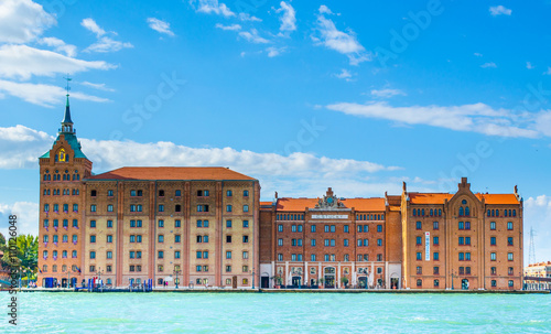 a giant cruise ship full of passengers is leaving italian city venice after busy touristic day. photo