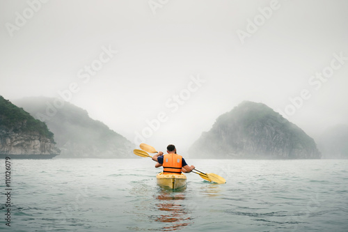 Couple paddling the kayak in mist weather