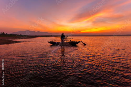 Tablou canvas Silhouette of traditional fishermen throwing net fishing inle lake at sunrise ti