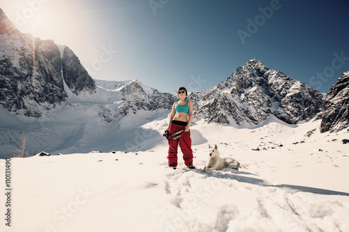 Young Happy Woman doing photo, enjoy and sunbathing in winter mountains with dog