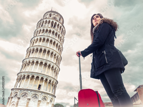 Fototapeta tourist woman with suitcase in Italy next to the Tower of Pisa