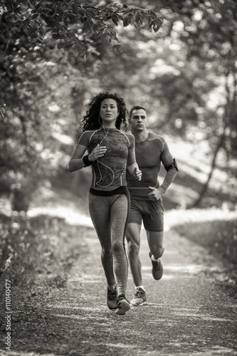 Young couple jogging at the park.Green environment.