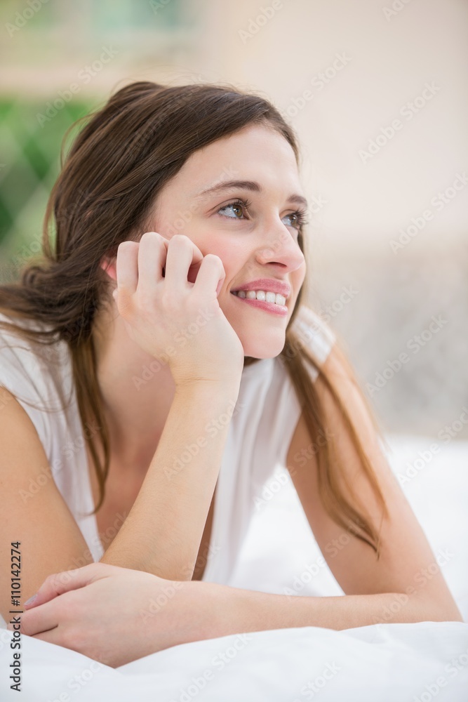Thoughtful smiling woman lying on bed Thoughtful smiling woman lying on bed