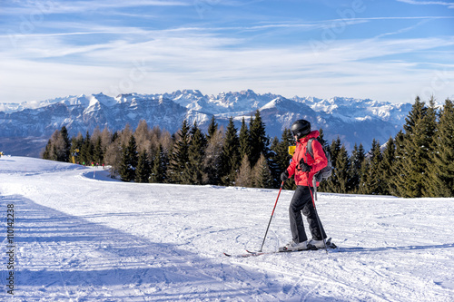 Картината върху платно Female skier enjoys view on italien slopes with beautiful mountains in distance