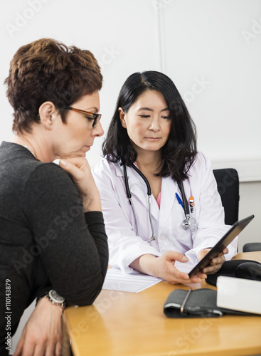 Doctor Showing Digital Tablet To Female Patient