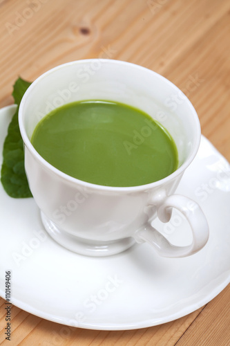 green tea with milk or hot matcha latte on wood