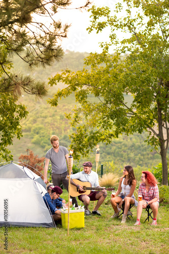 Young people in front of tent in nature