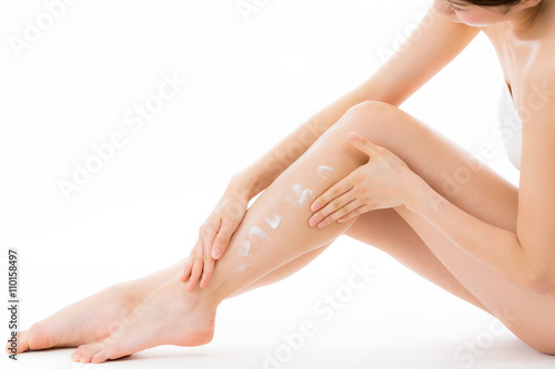 脚にクリームを塗る女性