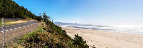 panoramic view of the huge beach of Maxwell point on the west coast of america with some people walking at the edge of the sea and the road during a sunny day of summer © ydumortier