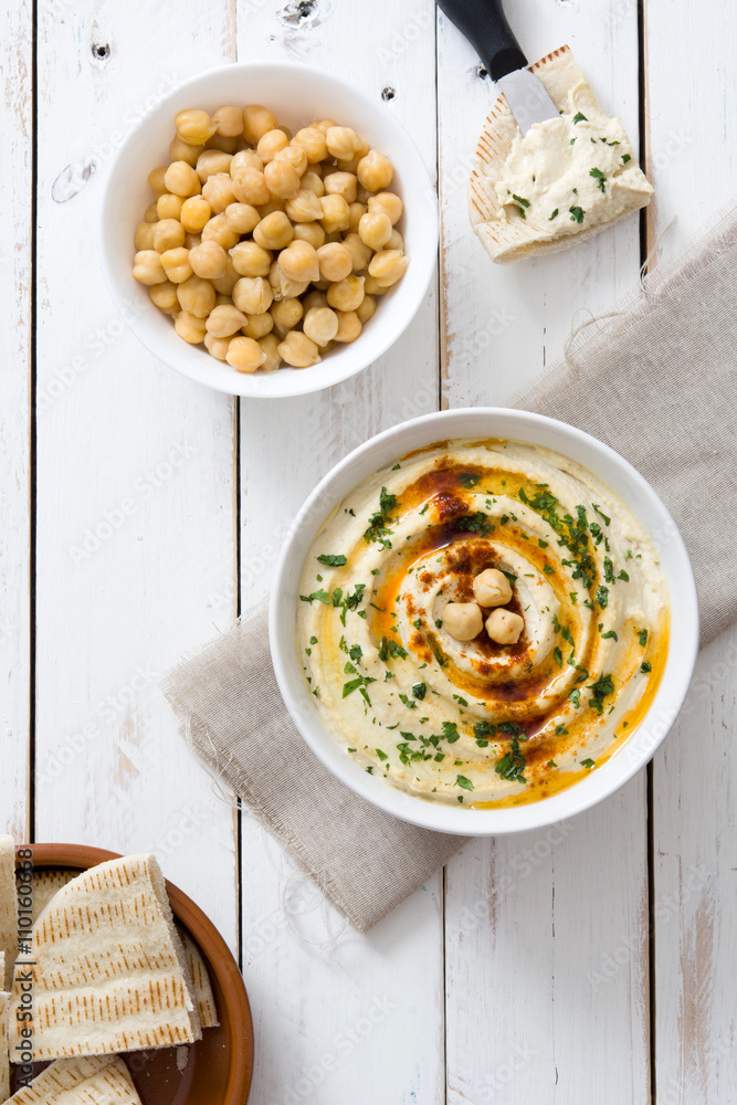 Hummus in bowl on white wooden table Hummus in bowl on white wooden table