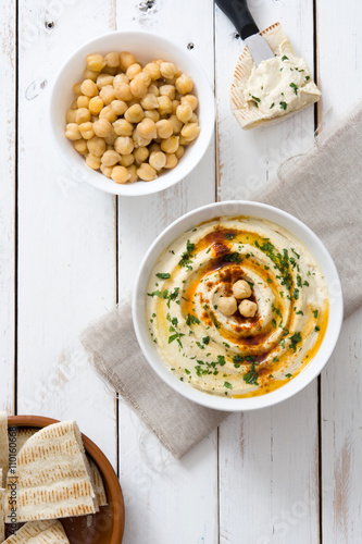 Hummus in bowl on white wooden table