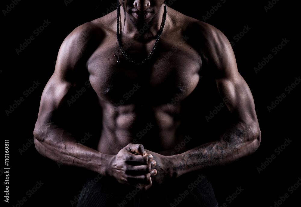 Studio shot of muscular afro-american man posing with black background