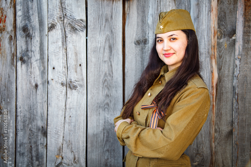 Obraz premium Beautiful young woman in a military uniform