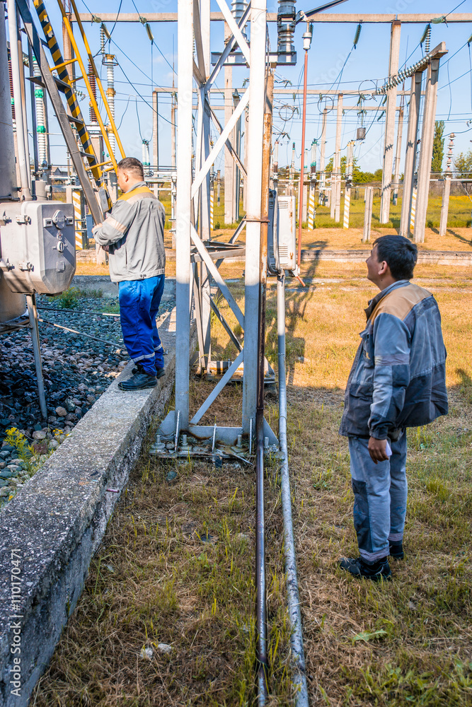 Fototapeta premium Electricians at the substation