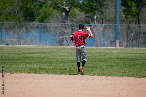 Teenage baseball shortstop from behind.