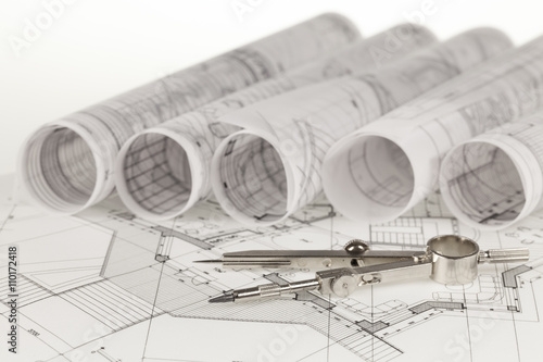 rolls of architecture blueprints, house plans & compass