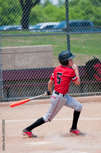 American teen baseball player swinging the bat.